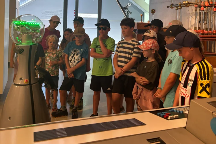 A group of children are watching a demonstration of scientific equipment intently