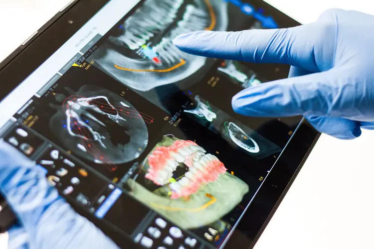 Hände mit blauen Handschuhen und Tablet