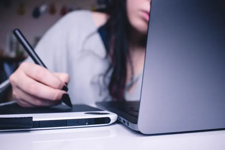 Studentin mit Laptop und digitalem Block & Stift