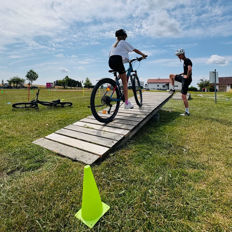 Child practising mountain biking: riding over a ramp
