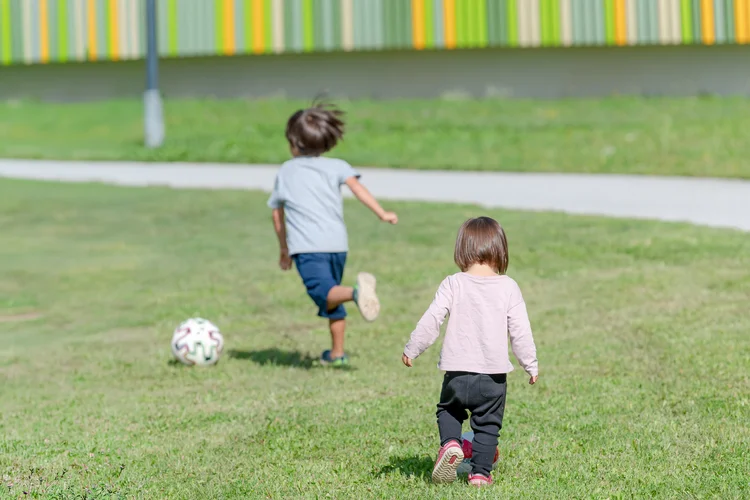 Mädchen und Bub beim Fußballspielen